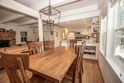 a kitchen and dining room with a wooden table and chairs at Hillhouse By Hauserman Rentals in Homewood