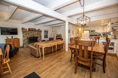 a living room with a dining table and a fireplace at Hillhouse By Hauserman Rentals in Homewood