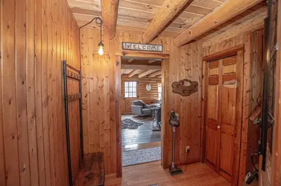 a hallway in a cabin with wooden walls and a door at Little Bear Cabin By Hauserman Rentals in Tahoe Vista