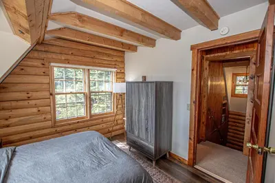 a bedroom with a bed and a wooden wall at Little Bear Cabin By Hauserman Rentals in Tahoe Vista