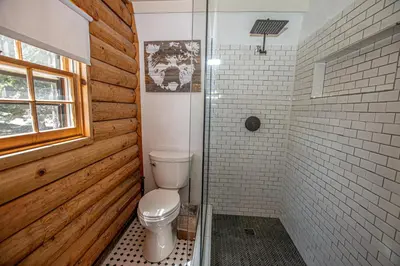 a bathroom with a toilet and a glass shower at Little Bear Cabin By Hauserman Rentals in Tahoe Vista