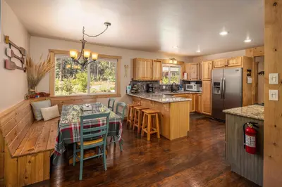 a kitchen with a table and a refrigerator at Cedarwood Serenity By Hauserman Rentals in Tahoe City