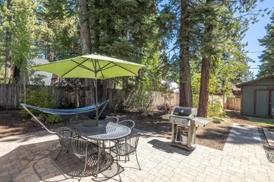 a patio with a table umbrella and a grill at Cedarwood Serenity By Hauserman Rentals in Tahoe City