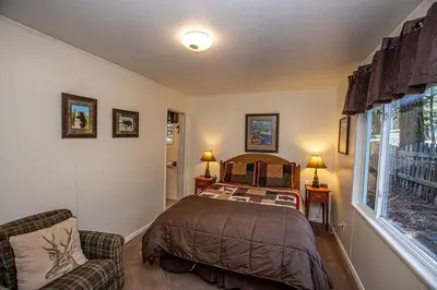 a bedroom with a bed and a chair and a window at Holland By Hauserman Rentals in Homewood