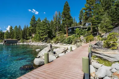 a wooden walkway next to a body of water at McCown Lakefront By Hauserman Rentals in Tahoma