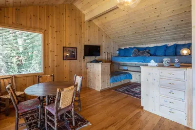a bedroom with a bed and a table and chairs at McCown Lakefront By Hauserman Rentals in Tahoma