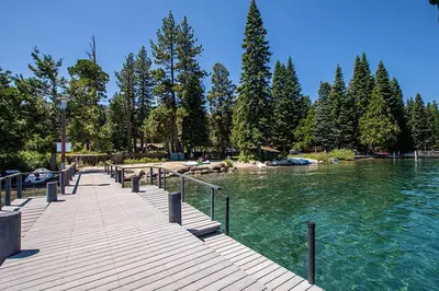 a wooden dock next to a river with trees at McKinney Cove By Hauserman Rentals in Homewood