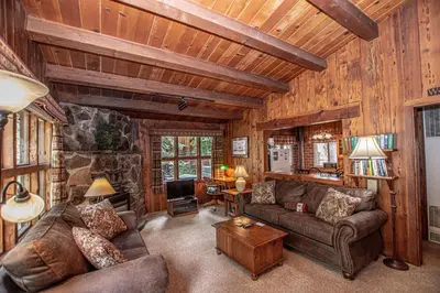 a living room with leather furniture and a stone wall at Plesums By Hauserman Rentals