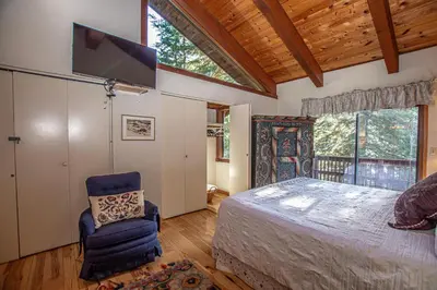 a bedroom with a bed and a tv and a chair at Home Swede Home By Hauserman Rentals in Tahoe City