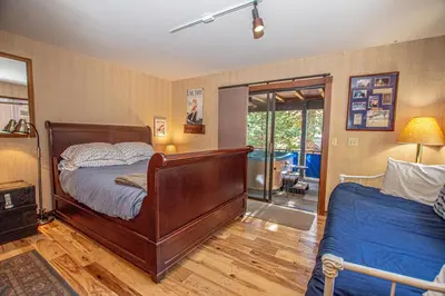 a bedroom with a wooden bed and a glass door at Home Swede Home By Hauserman Rentals in Tahoe City