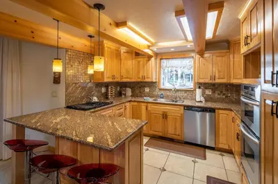 a kitchen with wooden cabinets and a granite counter top at Poplar Place By Hauserman Rentals in Homewood