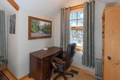 a desk and a chair in a room with a window at Poplar Place By Hauserman Rentals in Homewood