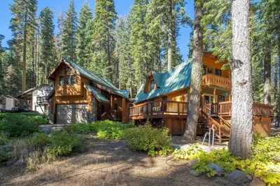 a log home in the woods with trees at Poplar Place By Hauserman Rentals in Homewood