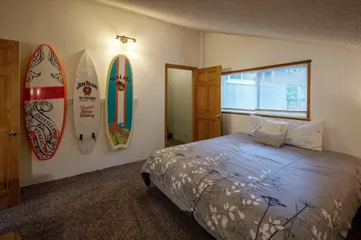 a bedroom with surfboards on the wall and a bed at Molly's Treehouse By Hauserman Rentals in Carnelian Bay