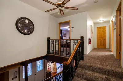a hallway with a clock on the wall and a staircase at Molly's Treehouse By Hauserman Rentals in Carnelian Bay