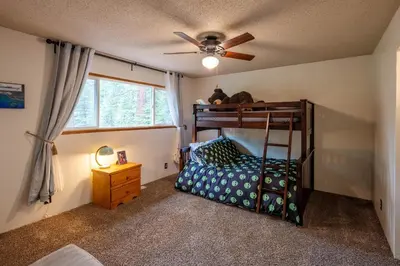 a bedroom with a bunk bed and a ceiling fan at Molly's Treehouse By Hauserman Rentals in Carnelian Bay