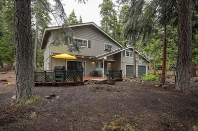 a house with a patio in the woods at Molly's Treehouse By Hauserman Rentals in Carnelian Bay