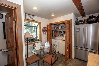 a kitchen with a glass table and a refrigerator at Rygh Lakefront By Hauserman Rentals in Carnelian Bay