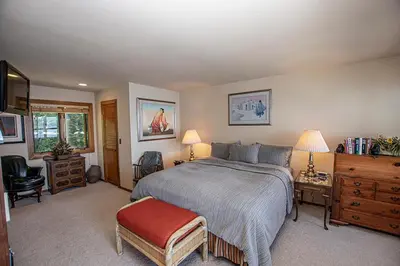a bedroom with a bed and a desk and a chair at Rygh Lakefront By Hauserman Rentals in Carnelian Bay