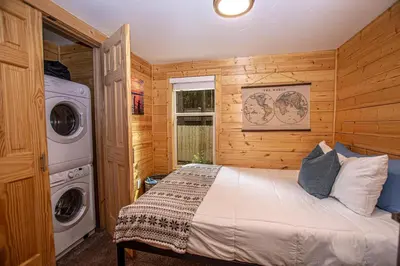 a bedroom with a bed and a washing machine at O'Brien's Den By Hauserman Rentals in Tahoma