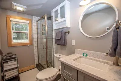 a bathroom with a toilet and a sink and a mirror at O'Brien's Den By Hauserman Rentals in Tahoma