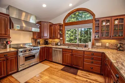 a kitchen with wooden cabinets and a window at Tahoe Haven By Hauserman Rentals in Carnelian Bay