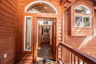 a hallway of a wooden house with a door and windows at Tahoe Haven By Hauserman Rentals in Carnelian Bay