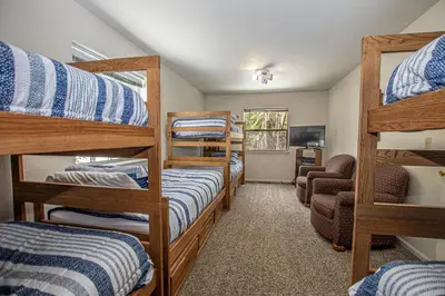 a room with four bunk beds and a chair at Shean By Hauserman Rentals in Tahoe City