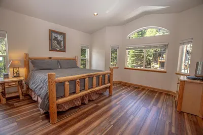 a bedroom with a bed and a table and windows at Sherman By Hauserman Rentals in Tahoma