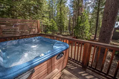 a jacuzzi tub on a deck in the woods at Sherman By Hauserman Rentals in Tahoma