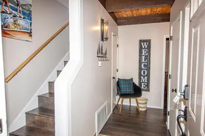 a hallway with a stairway with a chair and a stair case at St Francis #53 By Hauserman Rentals in Tahoe City