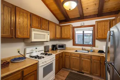 a kitchen with wooden cabinets and a white stove top oven at St Francis #14 By Hauserman Rentals in Tahoe City