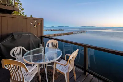 a table and chairs on a balcony overlooking the water at Star Harbor # 15 By Hauserman Rentals in Tahoe City