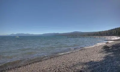 a beach with a pier in the water at Star Harbor # 15 By Hauserman Rentals in Tahoe City