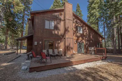 a wooden house with chairs and tables on a deck at Stephens Retreat By Hauserman Rentals in Carnelian Bay