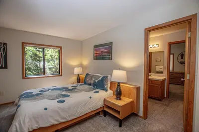 a bedroom with a large bed and a mirror at Stephens Retreat By Hauserman Rentals in Carnelian Bay
