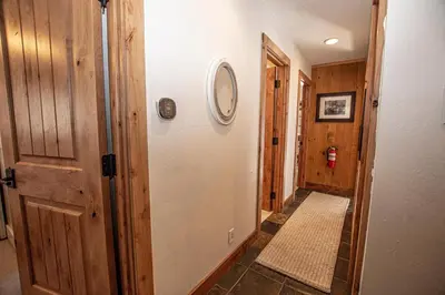 a hallway with a white door and a tile floor at Thunder Lodge By Hauserman Rentals in Homewood