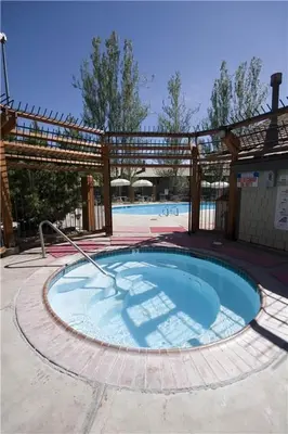 a large swimming pool with a wooden pergola at Lake Forest Glen # 114 By Hauserman Rentals in Tahoe City