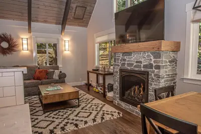 a living room with a stone fireplace at Price Haus By Hauserman Rentals in Tahoe City