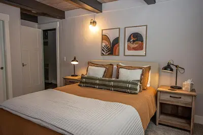 a bedroom with a bed with two lamps and two tables at Price Haus By Hauserman Rentals in Tahoe City