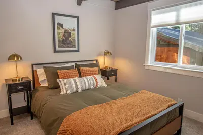a bedroom with a bed with two lamps and a window at Price Haus By Hauserman Rentals in Tahoe City