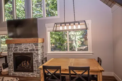 a dining room with a table and a fireplace at Price Haus By Hauserman Rentals in Tahoe City