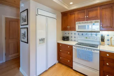 a kitchen with a white refrigerator and wooden cabinets at Star Harbor # 6 By Hauserman Rentals in Tahoe City
