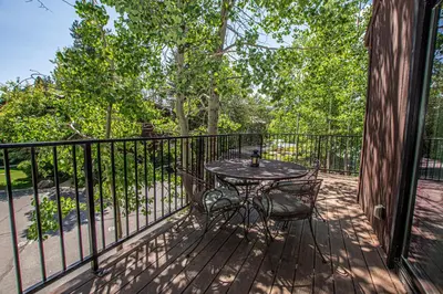 a table and chairs on a deck with a fence at St Francis #18 By Hauserman Rentals in Tahoe City