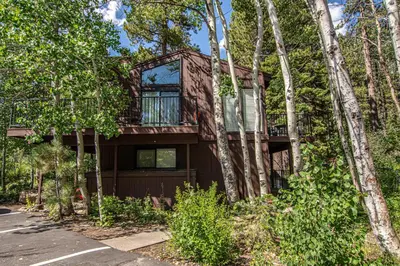 a house in the woods with trees at St Francis #18 By Hauserman Rentals in Tahoe City