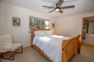 a bedroom with a bed and a fan and a chair at Daly's Digs By Hauserman Rentals in Tahoe City