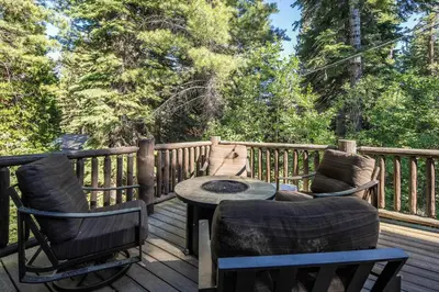 a wooden deck with two chairs and a table at Aspen Grove By Hauserman Rentals in Tahoe City