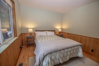 a bedroom with a bed and two tables with lamps at Knobcone Cabin by Hauserman Rental Group in Tahoma