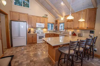 a kitchen with wooden cabinets and a white refrigerator at Knobcone Cabin by Hauserman Rental Group in Tahoma