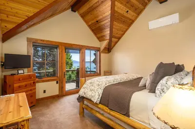 a bedroom with a bed and a tv andwindows at Peaceful Waters By Hauserman Rentals in Tahoma